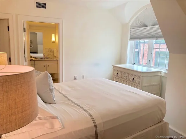 a bedroom with a bed and a large mirror