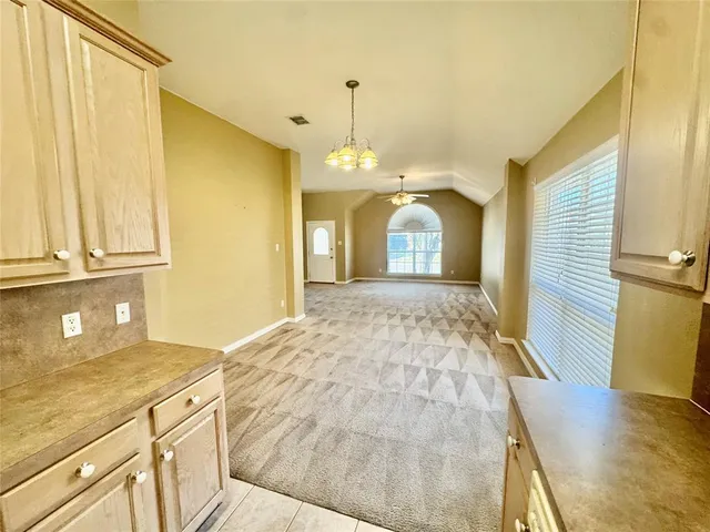 a view of a kitchen with granite countertop cabinets a sink and a large window