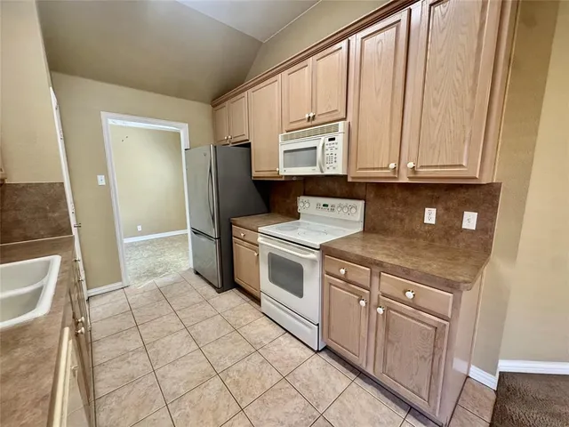 a kitchen with a stove top oven and cabinets
