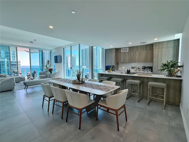a kitchen with a dining table chairs and white cabinets