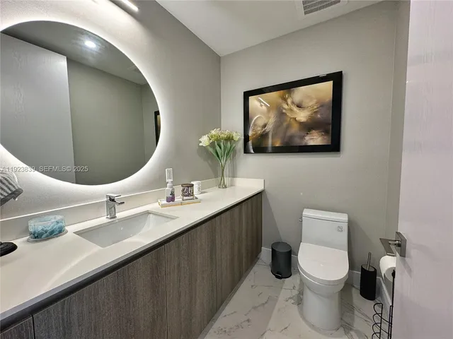 a bathroom with a toilet a sink and mirror
