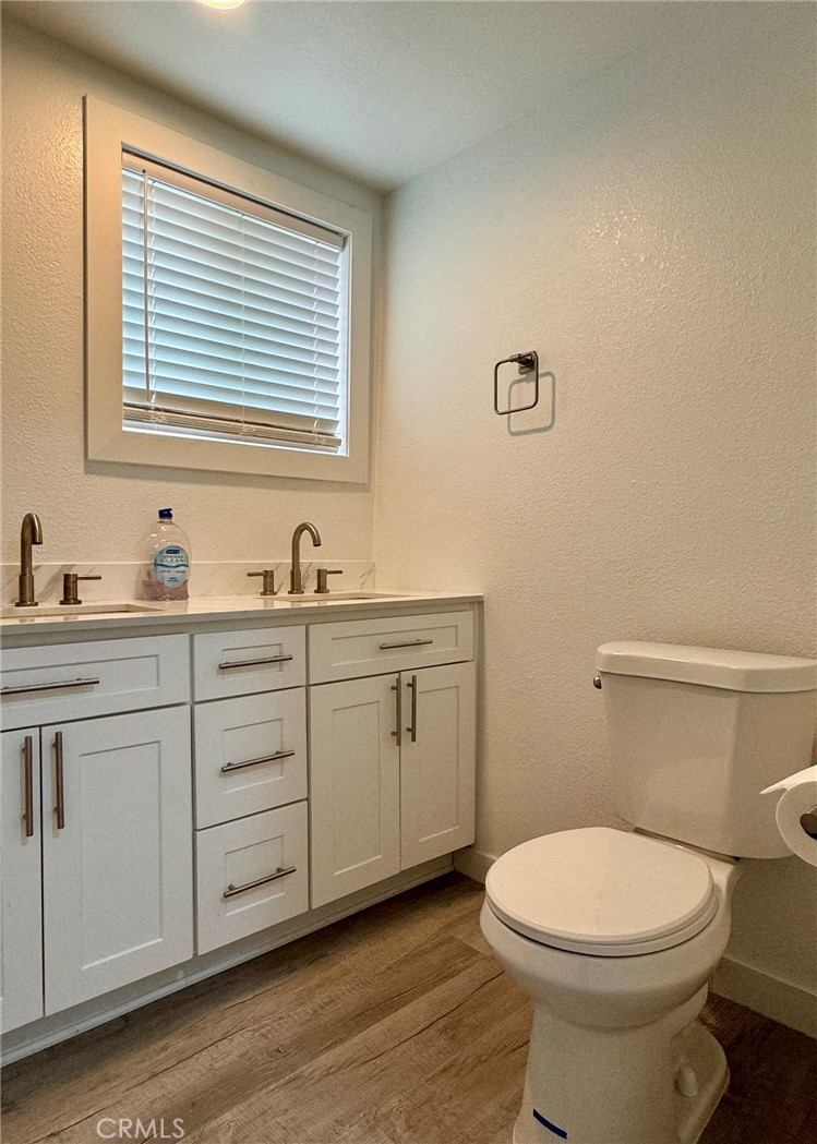 1362 South Downey Road Los Angeles, CA 90023 - Photo 22 of 30 a bathroom with a toilet a sink a vanity and mirror