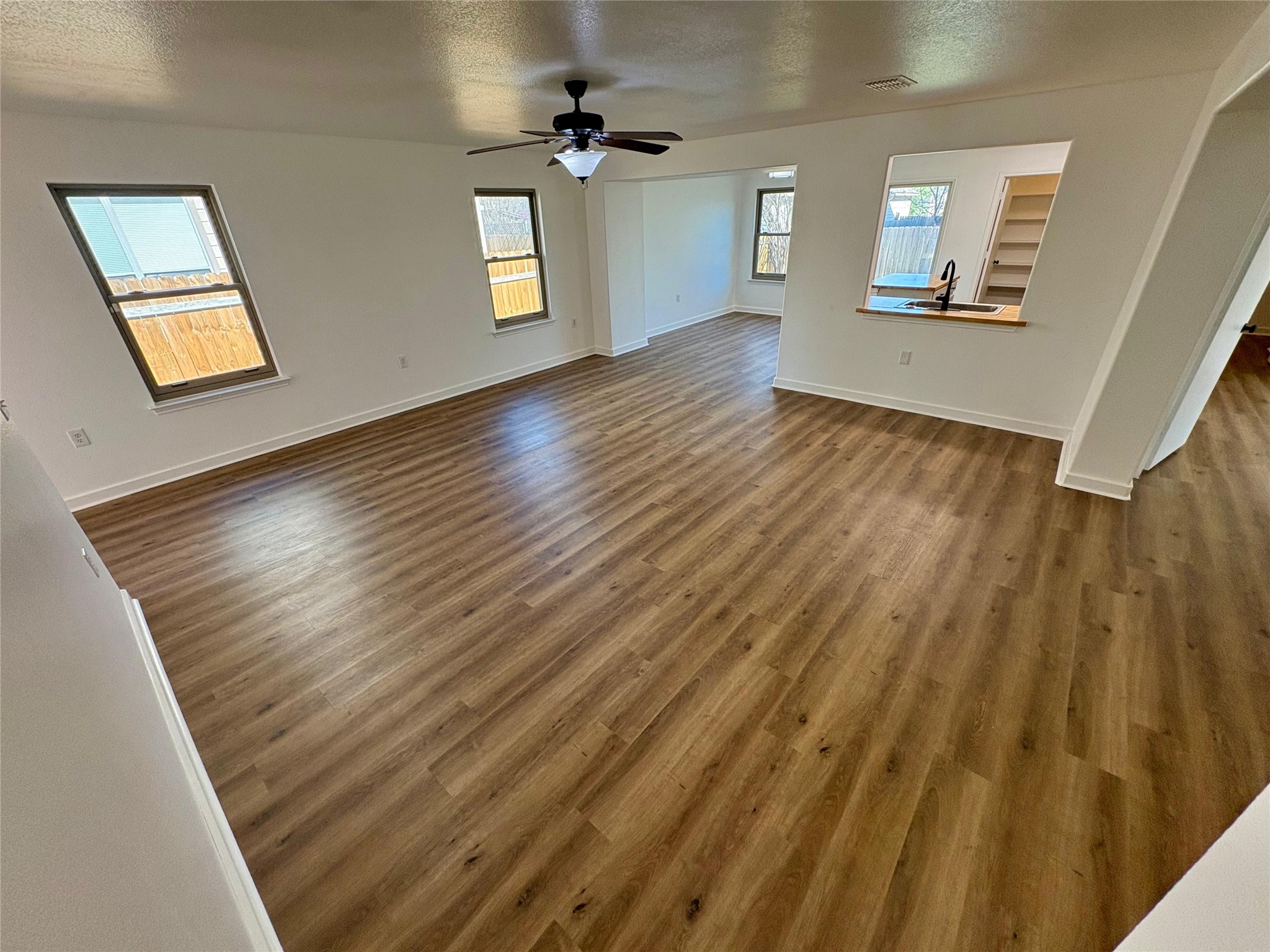 8003 Bannock Lane Austin, TX 78747 - Photo 7 of 40 Living room featuring a textured ceiling, dark wood-style flooring, and ceiling fan
