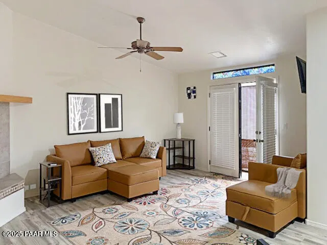 a living room with stainless steel appliances kitchen island granite countertop furniture and a wooden floor