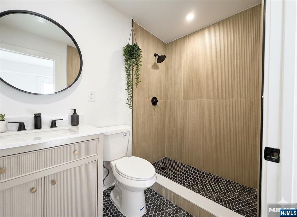 93 May Street Hawthorne, NJ 07506 - Photo 13 of 21 a bathroom with a sink a toilet and a mirror