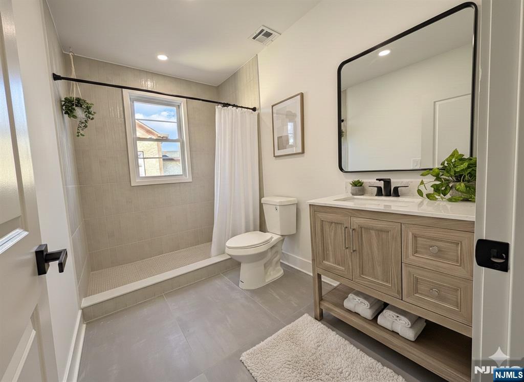 93 May Street Hawthorne, NJ 07506 - Photo 14 of 21 a bathroom with a toilet sink a mirror a vanity and window