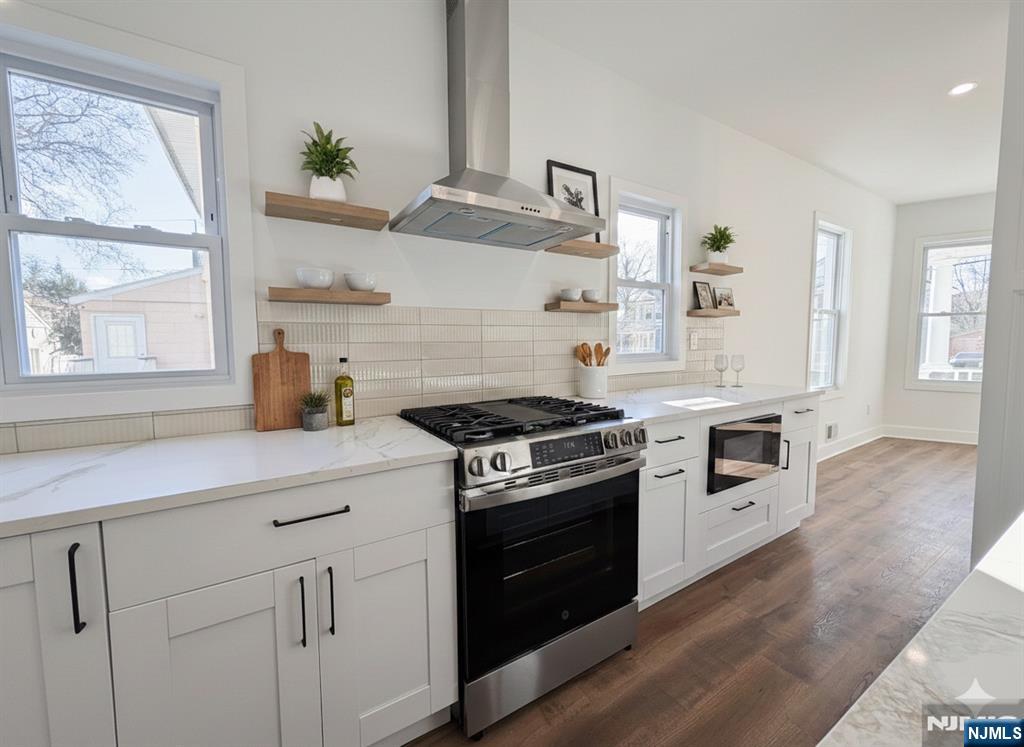 93 May Street Hawthorne, NJ 07506 - Photo 2 of 21 a kitchen with granite countertop cabinets stainless steel appliances and wooden floor