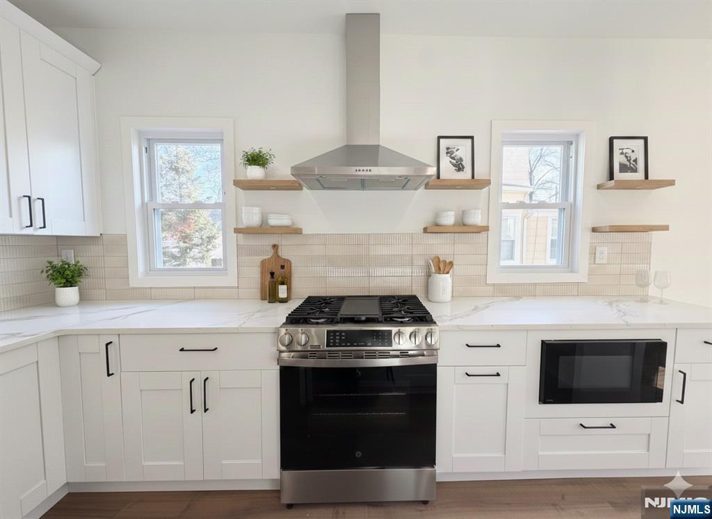93 May Street Hawthorne, NJ 07506 - Photo 3 of 21 a kitchen with stainless steel appliances a stove a white cabinet and a microwave