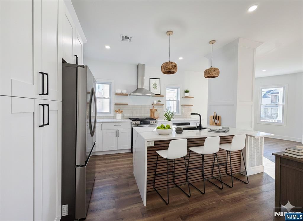93 May Street Hawthorne, NJ 07506 - Photo 4 of 21 a kitchen with a table chairs refrigerator and microwave