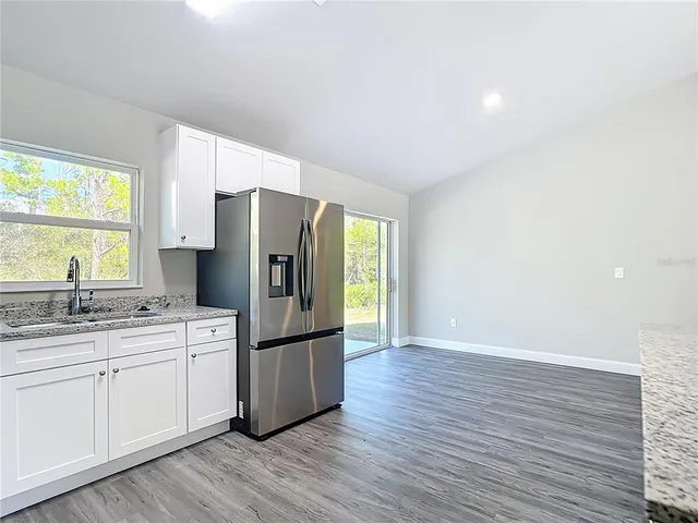 a kitchen with a refrigerator sink and cabinets