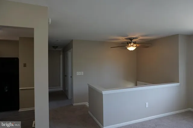 a view of an livingroom with a ceiling fan and window