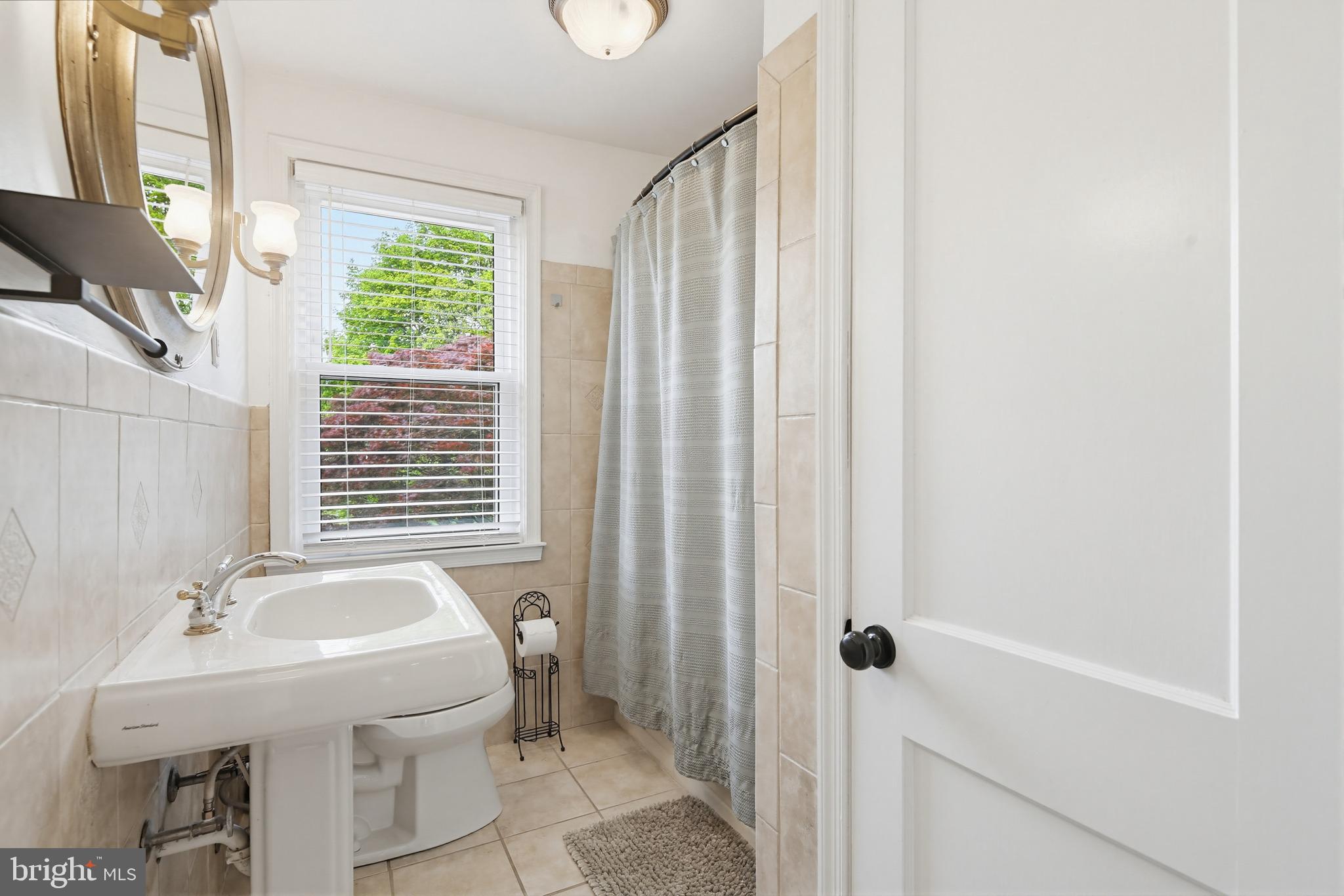 8111 Barksdale Road Baltimore, MD 21286 - Photo 22 of 39 a bathroom with a sink a toilet and shower curtain