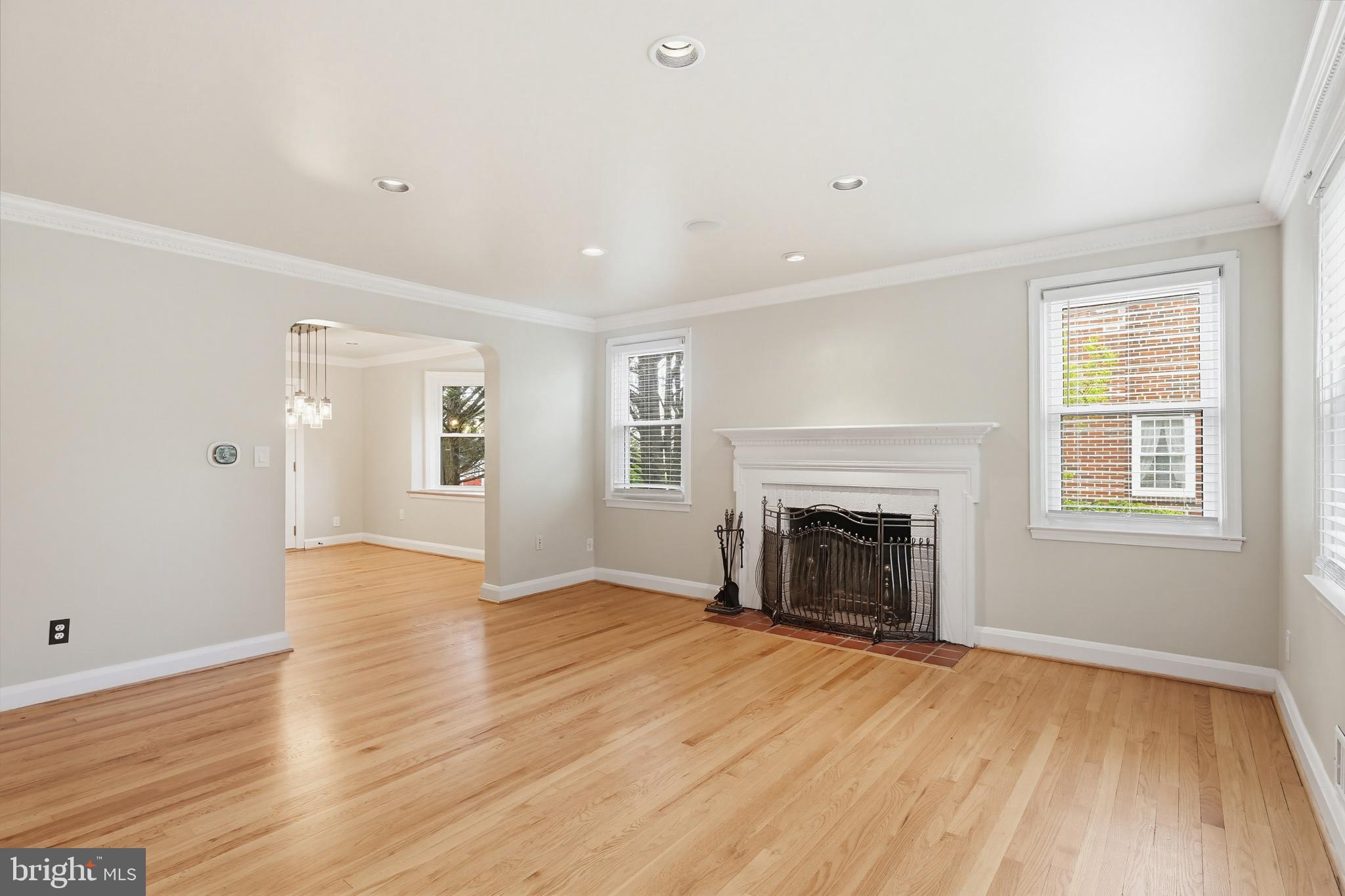 8111 Barksdale Road Baltimore, MD 21286 - Photo 7 of 39 an empty room with wooden floor fireplace and windows