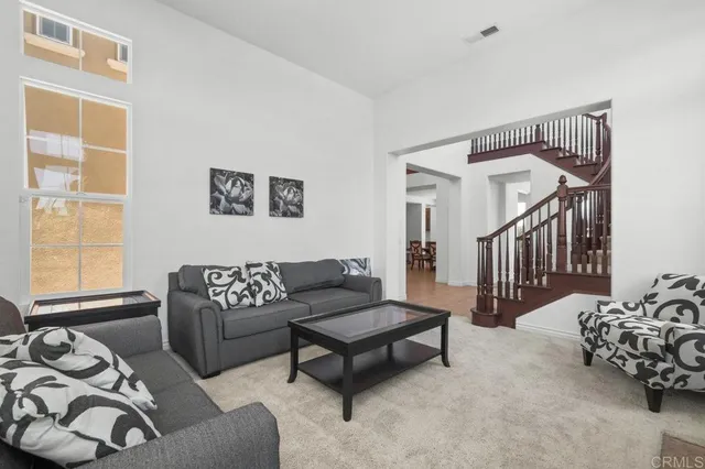 a living room with furniture a rug and a window