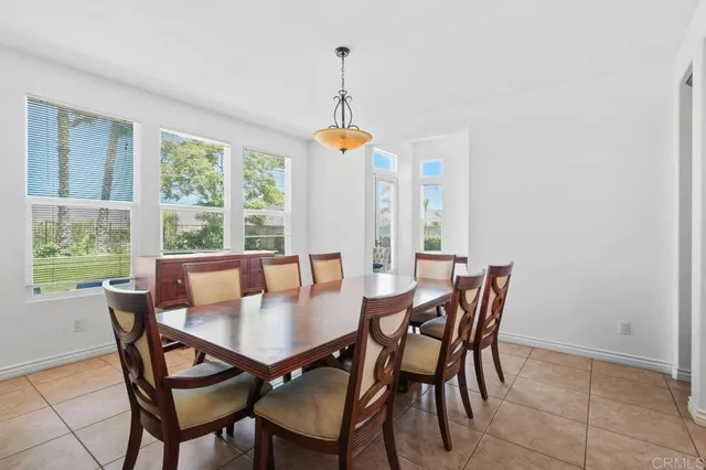 a kitchen with stainless steel appliances granite countertop a table chairs sink and cabinets