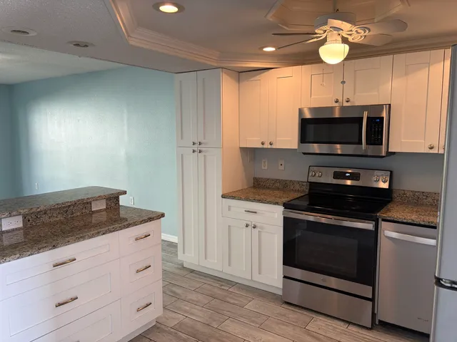 a kitchen with stainless steel appliances granite countertop a stove a microwave and a sink