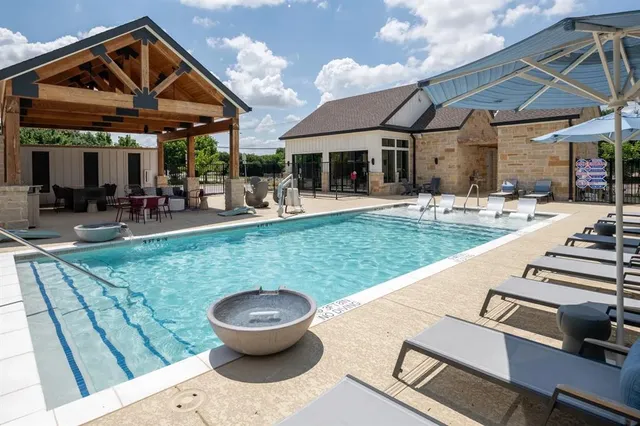 a view of a patio with table and chairs potted plants and floor to ceiling window
