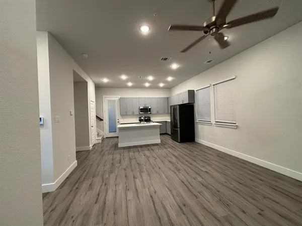 a view of a kitchen with a sink stainless steel appliances and wooden floor