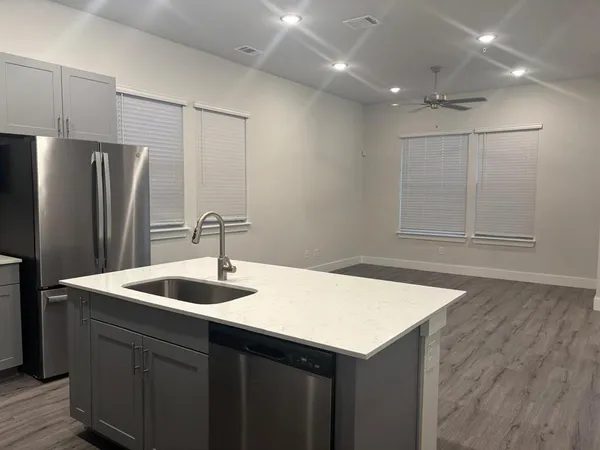 a kitchen with kitchen island a sink stove and refrigerator
