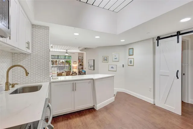 a kitchen with white cabinets and sink