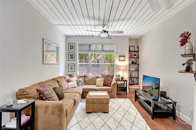 a living room with furniture a chandelier and a flat screen tv