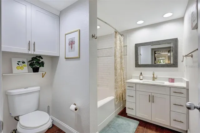 a bathroom with a toilet a sink a mirror a vanity and shower