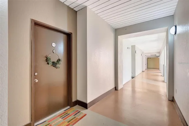 a view of a hallway with wooden floor and closet