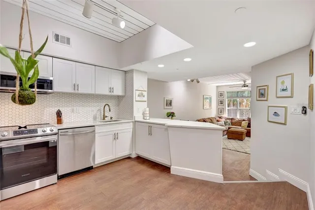 a kitchen with white cabinets and white appliances