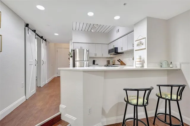 a kitchen with stainless steel appliances granite countertop a sink and a refrigerator