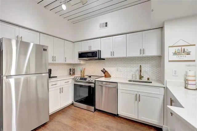 a kitchen with white cabinets sink and white appliances