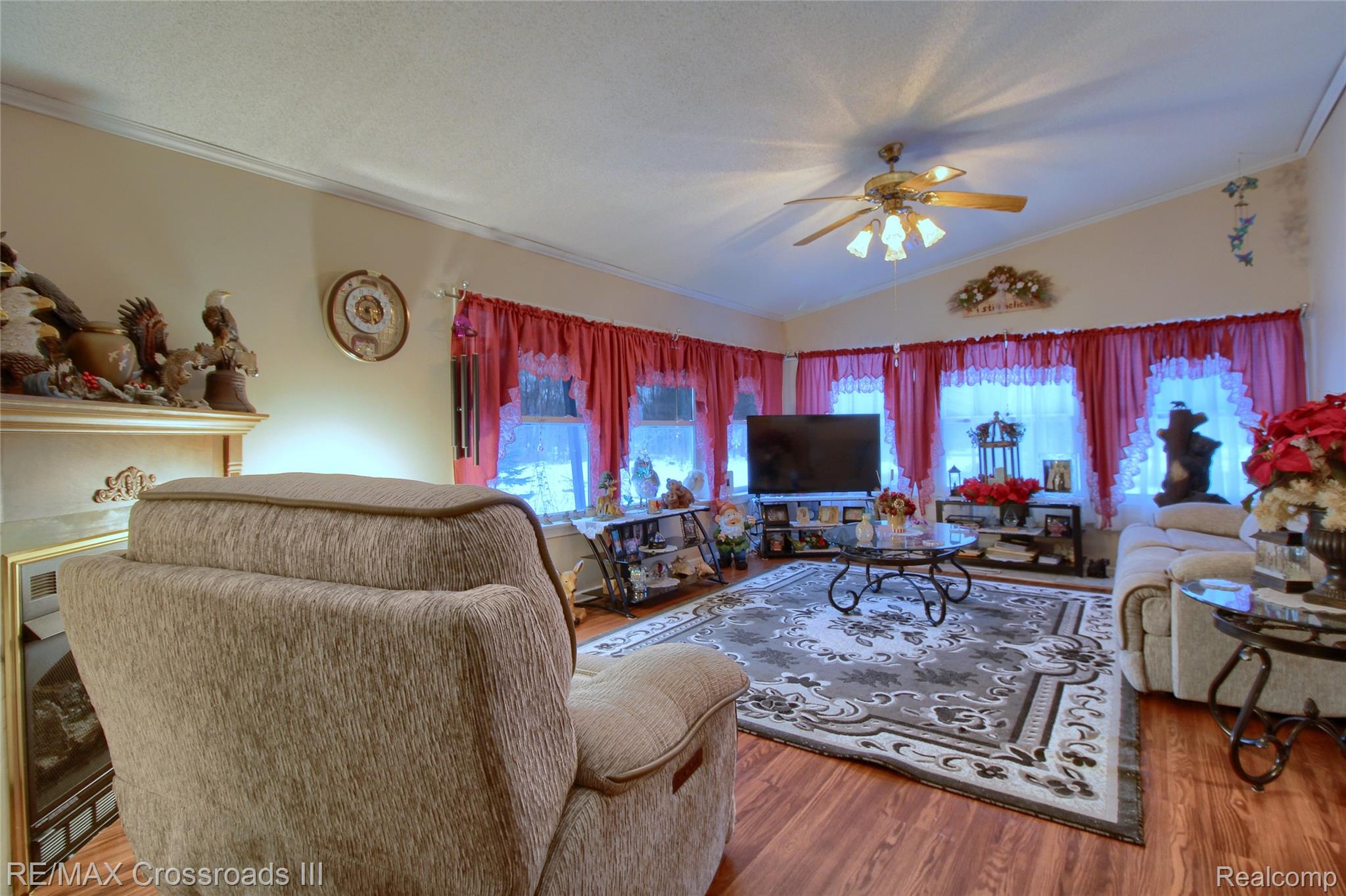 48620 Wear Road Belleville, MI 48111 - Photo 11 of 24 Living room with vaulted ceiling, wood finished floors, plenty of natural light, a ceiling fan, and crown molding