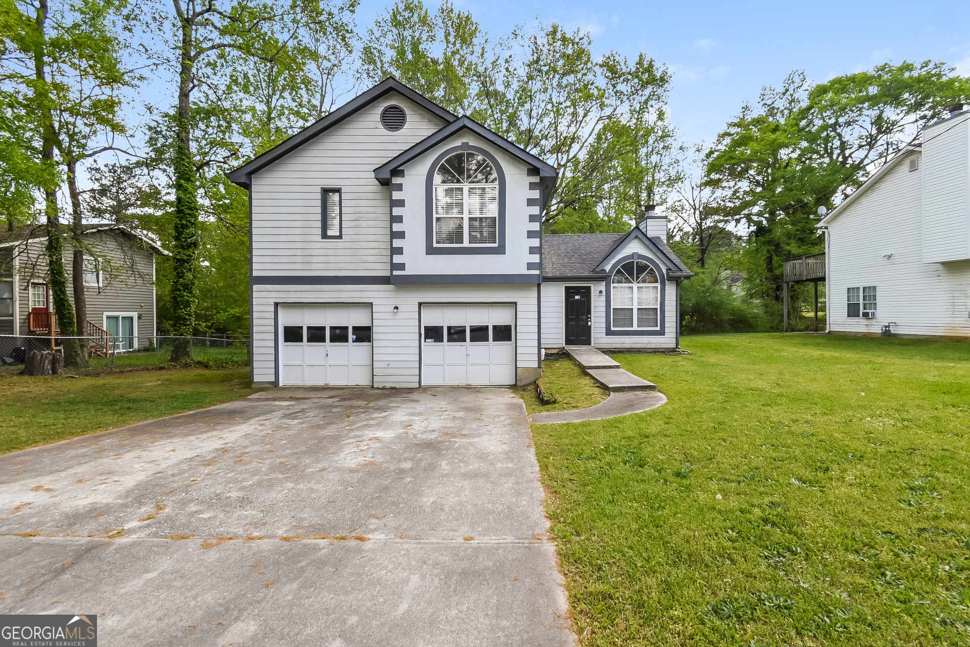 a view of a house with a big yard and large trees