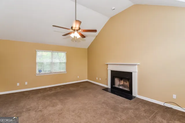 a view of an empty room with window and fireplace