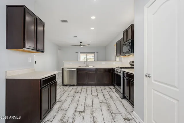 a large kitchen with stainless steel appliances granite countertop a sink and cabinets