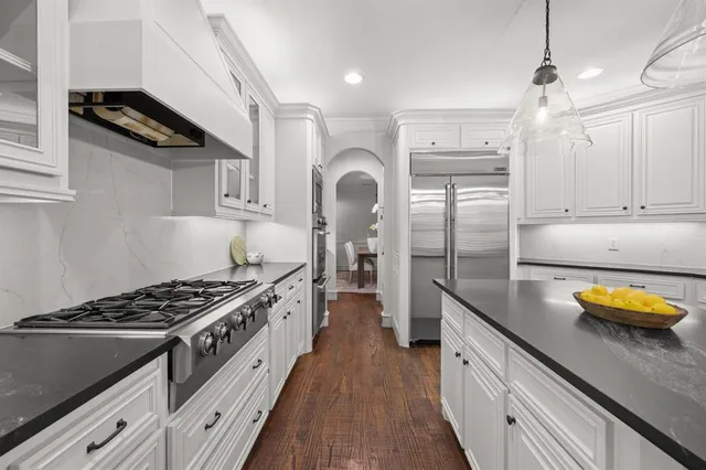 a kitchen with stainless steel appliances granite countertop a stove a sink and a refrigerator