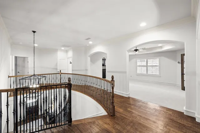 a view of hallway with a window and wooden floor