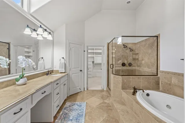 a spacious bathroom with a granite countertop sink mirror and bathtub
