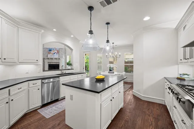 a kitchen with granite countertop white cabinets and a stove