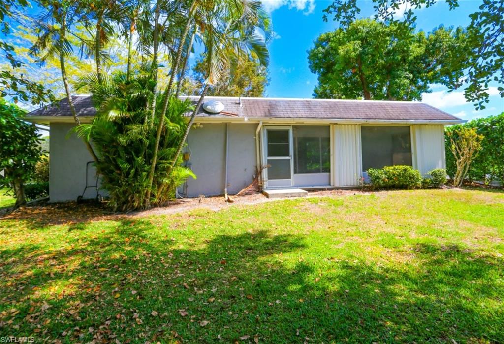 225 Georgetown Boulevard Naples, FL 34112 - Photo 11 of 37 Back of property featuring a lawn