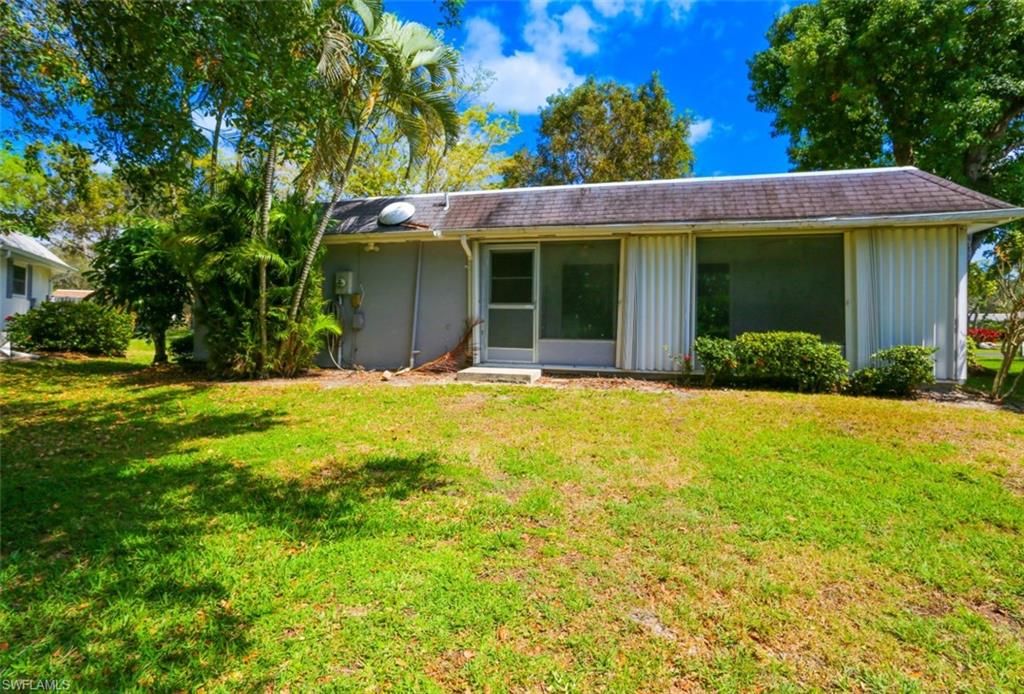 225 Georgetown Boulevard Naples, FL 34112 - Photo 12 of 37 Rear view of property featuring a lawn