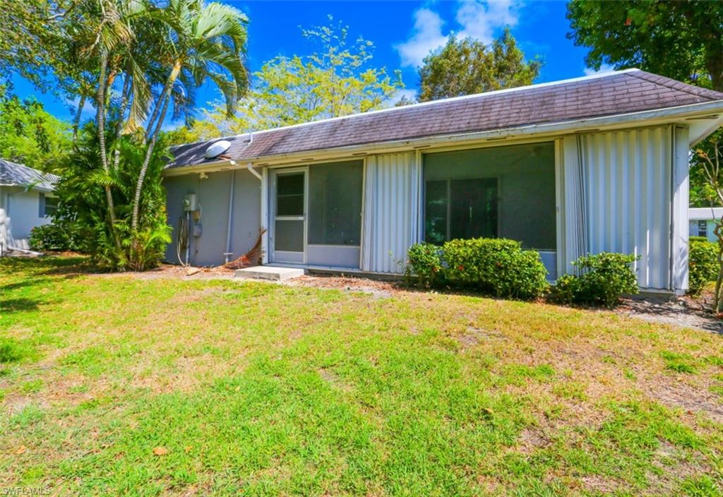 225 Georgetown Boulevard Naples, FL 34112 - Photo 13 of 37 Back of house with a lawn