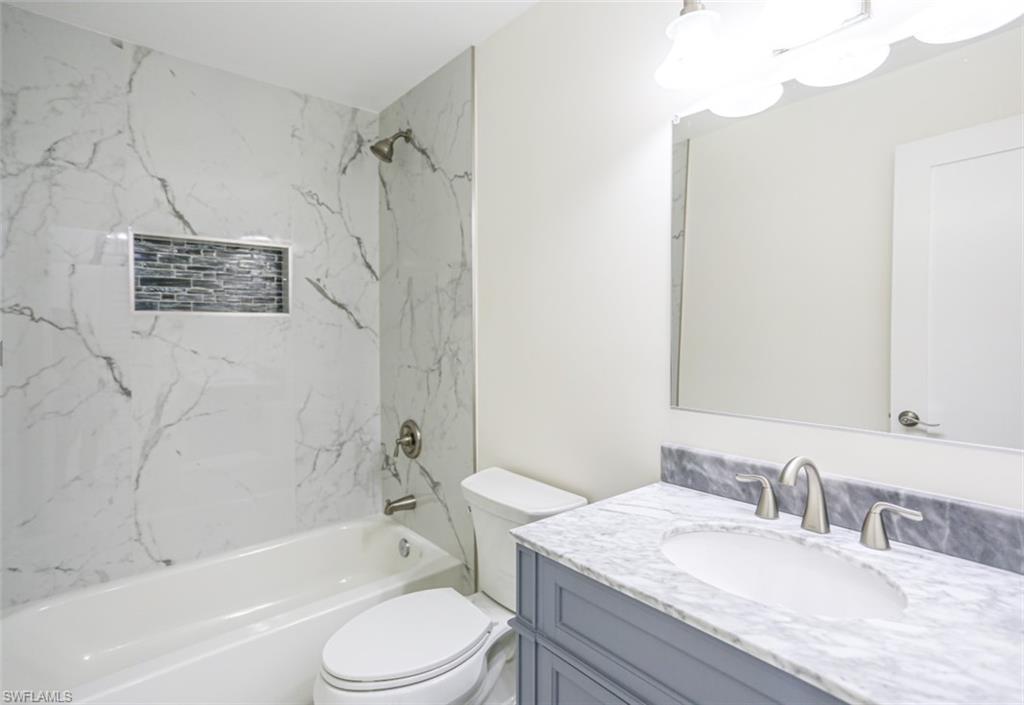 225 Georgetown Boulevard Naples, FL 34112 - Photo 28 of 37 Full bathroom featuring toilet, vanity, and tiled shower / bath
