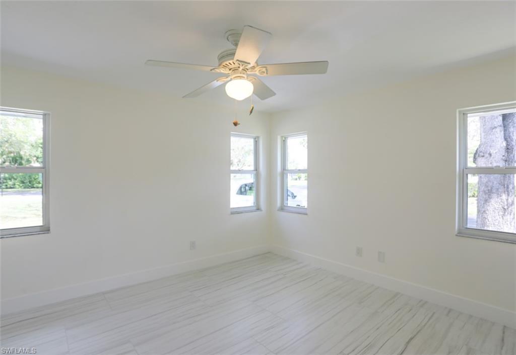 225 Georgetown Boulevard Naples, FL 34112 - Photo 30 of 37 Empty room with ceiling fan and a healthy amount of sunlight