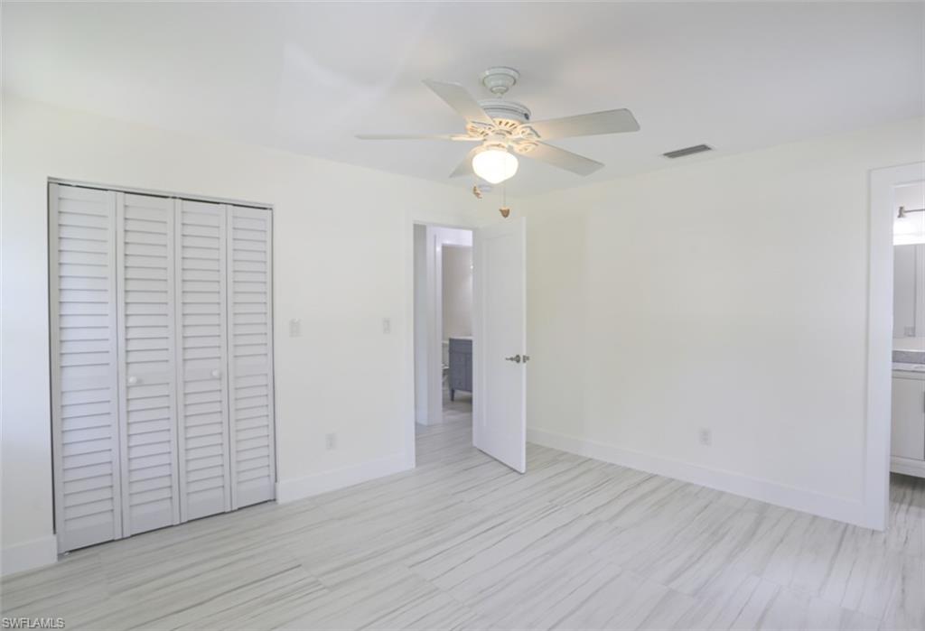 225 Georgetown Boulevard Naples, FL 34112 - Photo 31 of 37 Unfurnished bedroom featuring a closet, connected bathroom, and ceiling fan