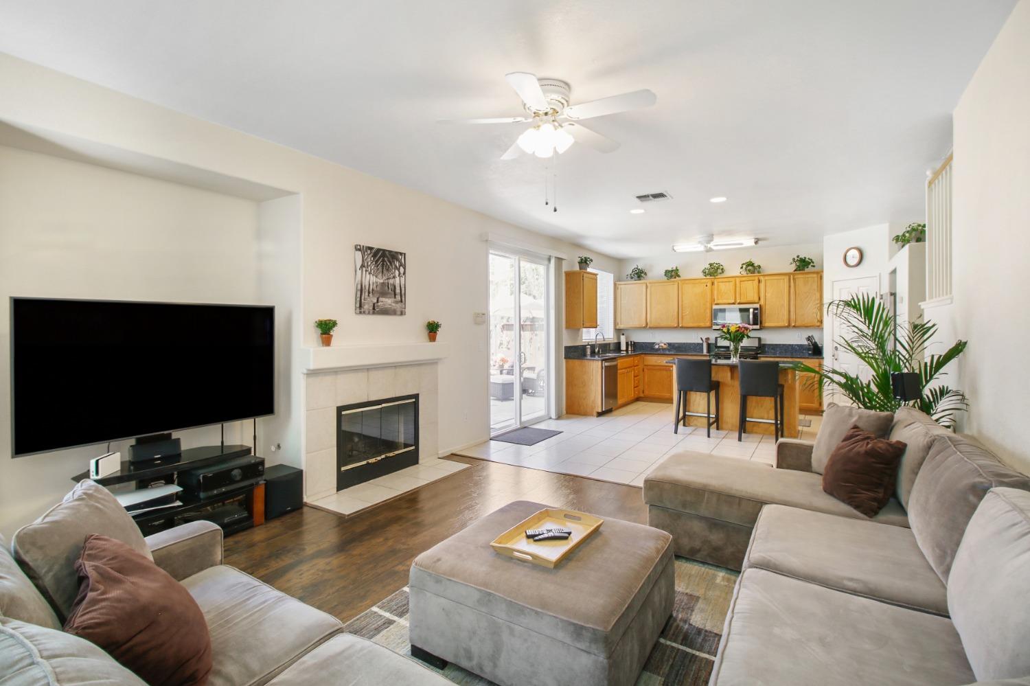 11568 Pyrites Court Gold River, CA 95670 - Photo 13 of 60 a living room with furniture a fireplace and a flat screen tv