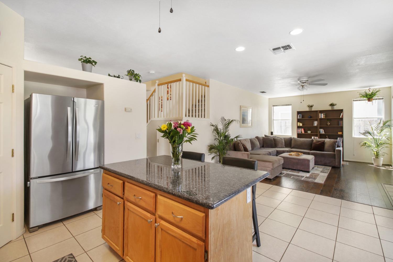 11568 Pyrites Court Gold River, CA 95670 - Photo 19 of 60 a kitchen with granite countertop a refrigerator and a counter space