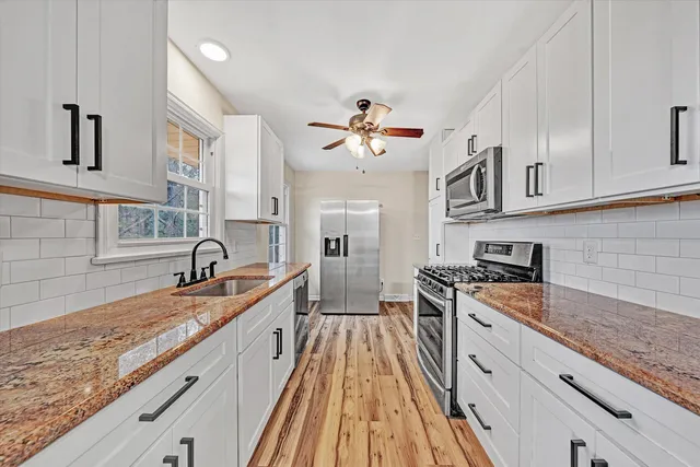 a kitchen with a sink window and cabinets