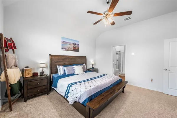 a large bed sitting in a bedroom and a chandelier