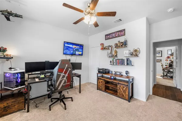 a view of a workspace with furniture and a ceiling fan