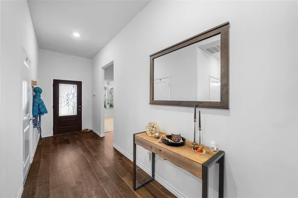 a view of a livingroom with wooden floor and a bathroom